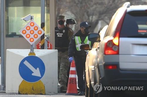 U.S. Forces Korea (USFK) officials check vehicles at a gate of Camp Walker in South Korea's southeastern city of Daegu on Feb. 20, 2020. (Yonhap)