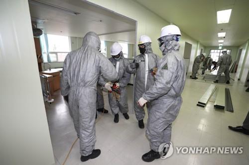 Troops set up makeshift partitions and beds at the Armed Forces Hospital in Daegu, 300 kilometers southeast of Seoul, on Feb. 28, 2020. The extra beds are being prepared to cope with the spike in patients testing positive for the novel coronavirus in the city. (Yonhap)