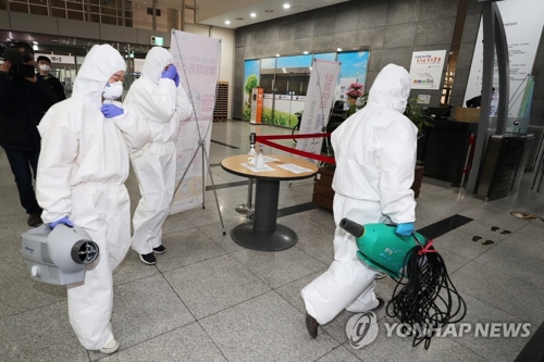 Health officials enter the health ministry in Sejong on March 7, 2020, after a public servant working for the ministry was diagnosed with COVID-19. (Yonhap)