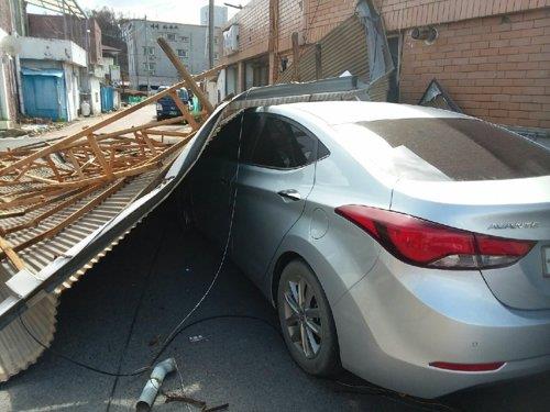This photo, provided by Gyeongbuk Fire Service Headquarters, shows a car destroyed by part of a collapsed roof in the aftermath of typhoon-class strong winds in Sangju, southeastern South Korea, on March 19, 2020. (PHOTO NOT FOR SALE) (Yonhap)