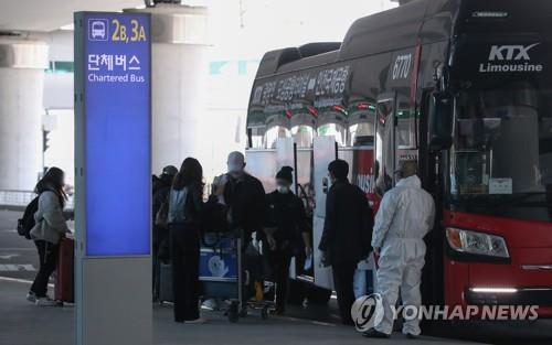 Entrants from Europe who have no COVID-19 symptoms board a bus bound for the KTX station in Gwangmyeong, south of Seoul, at the second terminal of Incheon International Airport, west of Seoul, on March 29, 2020. (Yonhap)