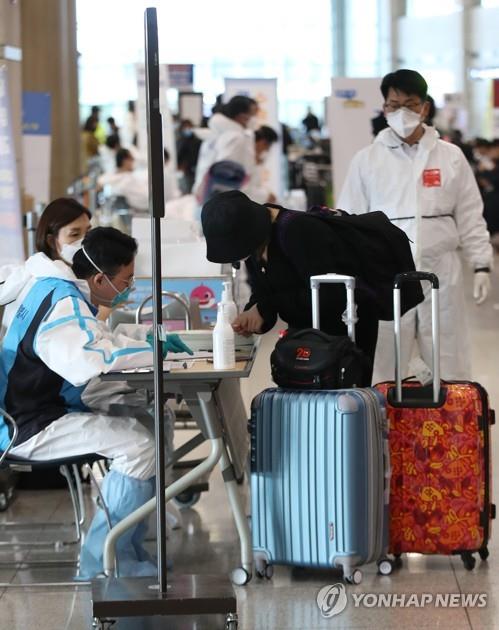 Airport officials introduce buses arranged exclusively for passengers from abroad at Incheon International Airport, west of Seoul, on April 1, 2020. From the day, all entrants were obliged to enter two-week self-isolation to avoid virus infections. (Yonhap)