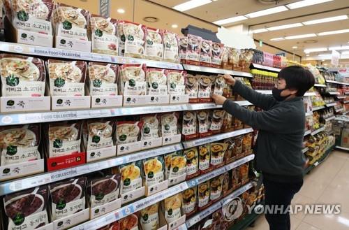 A worker at a Seoul retail outlet puts goods on display on March 12, 2020, in this file photo. There have been no signs of panic buying in South Korea since the World Health Organization declared the ongoing global COVID-19 crisis a pandemic the previous day. (Yonhap)