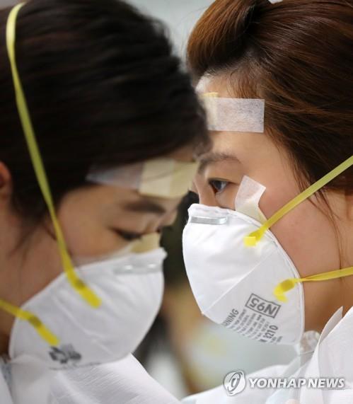 Medical workers, with adhesive bandages on their brows and noses to prevent abrasions, wear protective gear for a shift that involves taking care of COVID-19 patients at Dongsan Hospital in Daegu, 302 kilometers southeast of Seoul, on April 13, 2020. (Yonhap)