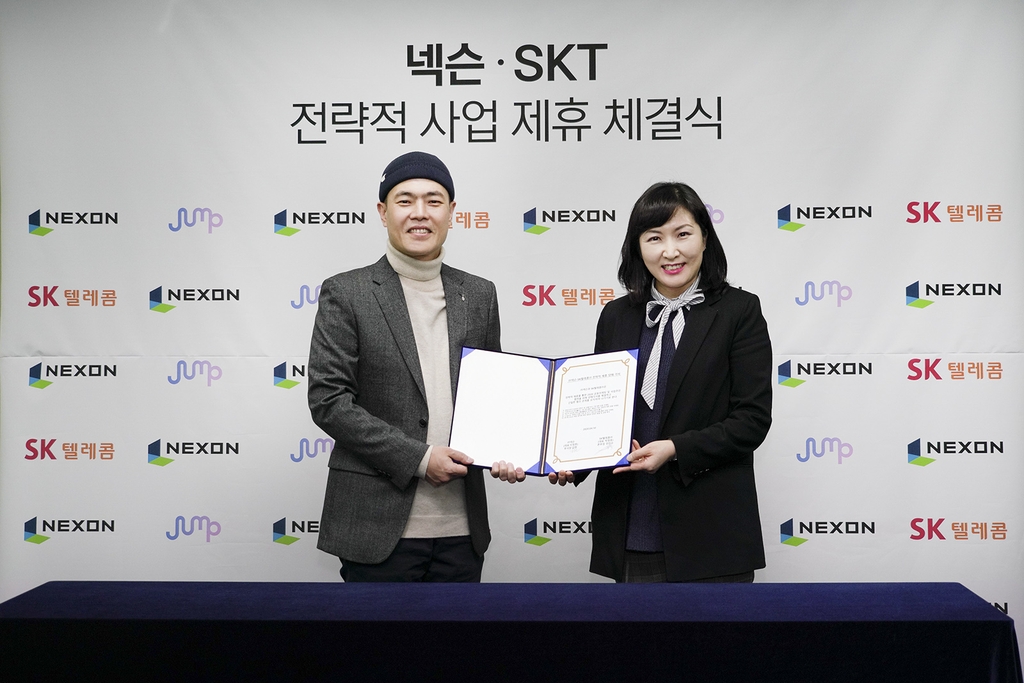 In this photo provided by SK Telecom Co. on April 13, 2020, Nexon Vice President Kim Hyun (L) and Jeon Jin-soo, head of SK Telecom's 5GX service business division, pose for a photo after signing a partnership in Seoul. (PHOTO NOT FOR SALE) (Yonhap)