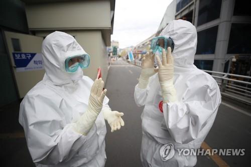 Medical workers in protective gear speak to each other before starting their work at Keimyung University Dongsan Medical Center in Daegu, 300 kilometers southeast of Seoul, on April 13, 2020. (Yonhap)