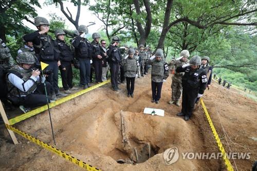 Defense Minister Jeong Kyeong-doo (2nd from R) salutes before the remains of a South Korean soldier killed in the 1950-53 Korean War inside the Demilitarized Zone (DMZ) on June 11, 2019. The remains were found during a recent excavation project on Arrowhead Ridge, a former battle site in the northern border county of Cherwon. (Pool photo) (Yonhap)