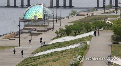 Visitors take a stroll at a park in Yeouido, western Seoul, on April 19, 2020. (Yonhap)