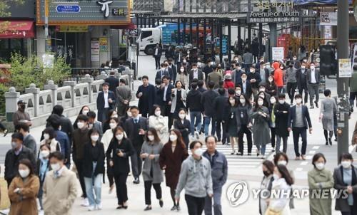 People wearing masks walk in Seoul's Jongno Ward on April 20, 2020, as South Korea began the same day to partly soften its social distancing guidelines amid the coronavirus pandemic. Under the measure, churches, bars, gyms and cram schools are allowed to resume business. (Yonhap)