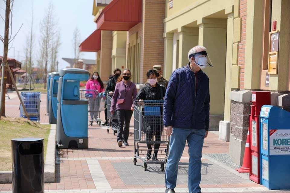 This photo, captured from U.S. Forces Korea's Facebook post on April 28, 2020, shows people wearing masks and maintaining a distance from one another while heading to a grocery shop. (PHOTO NOT FOR SALE) (Yonhap) 
