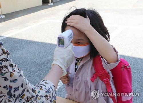 A pupil has her temperature checked at Ochi Elementary School in the southwestern city of Gwangju on May 29, 2020, amid the coronavirus pandemic. (Yonhap)