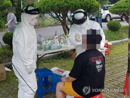A medical worker collects a sample from a person at a coronavirus screening clinic in Okcheon, North Chungcheong Province, on June 28, 2020, in this photo provided by the city government. (PHOTO NOT FOR SALE) (Yonhap)