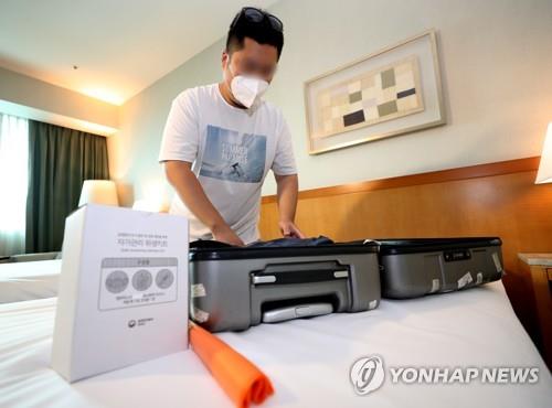 This photo taken by Joint Press Corps on Aug. 5, 2020, shows a health worker demonstrating what self-isolators need to do at a temporary quarantine shelter in Incheon. (Yonhap)