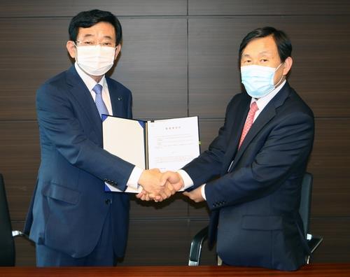 This photo provided by KCC Glass shows the CEOs of KCC and Korea Autoglass shaking hands after signing a merger deal in Seoul on Sept. 9, 2020. (PHOTO NOT FOR SALE) (Yonhap) 