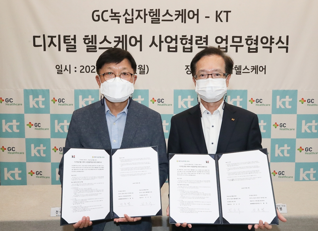 KT Corp. Vice President Jeon Hong-beom (R) and Green Cross Healthcare Co. CEO Jeon Do-kyu (L) pose for a photo after signing an agreement to develop a personalized health care service on Sept. 14, 2020, in this photo provided by KT. (PHOTO NOT FOR SALE)(Yonhap)