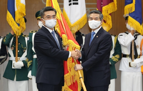New Defense Minister Suh Wook (L) shakes hands with his predecessor, Jeong Kyeong-doo, during his inauguration ceremony in Seoul on Sept. 18, 2020, in this photo provided by his office. (PHOTO NOT FOR SALE) (Yonhap)