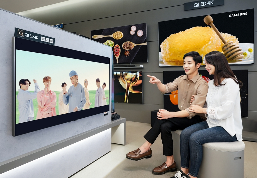This photo provided by Samsung Electronics Co. on Oct. 8, 2020, shows models watching the music video of "Dynamite," K-pop sensation BTS' latest single, on Samsung's QLED TV. (PHOTO NOT FOR SALE) (Yonhap)