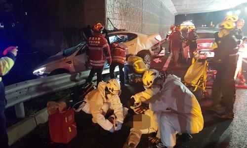 This photo provided by the Incheon Seobu Fire Station shows firefighters taking care of injured people after an accident on the Incheon International Airport Expressway in Incheon, west of Seoul, on Nov. 26, 2020. (PHOTO NOT FOR SALE) (Yonhap)