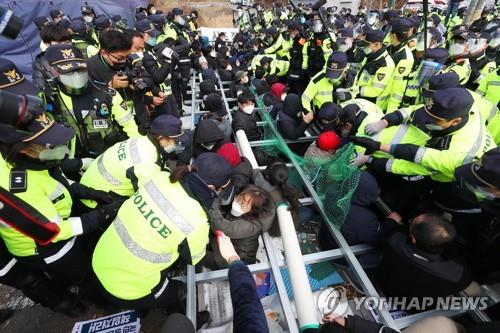 Riot police attempt to disperse protesters opposed to the delivery of construction equipment onto a THAAD base in Seongju, central South Korea, on Nov. 27, 2020. (Yonhap)