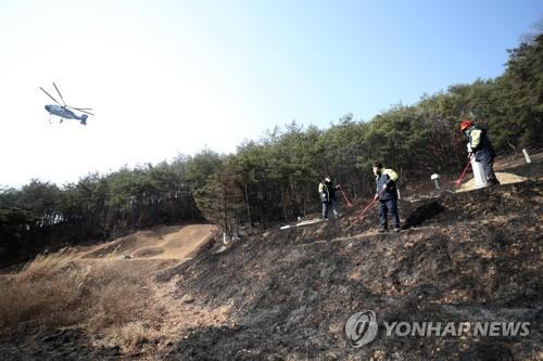 Firefighters work to put out the remaining fires in Andong, North Gyeongsang Province, on Feb. 22, 2021. (Yonhap)