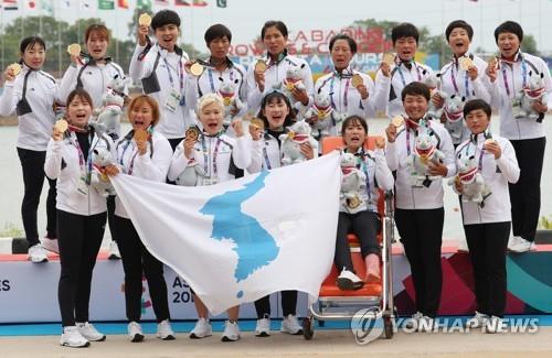 In this file photo from Aug. 26, 2018, members of the unified Korean women's dragon boat racing team stand on the podium during the medal ceremony after winning gold in the women's 500-meter race at the 18th Asian Games in Palembang, Indonesia. (Yonhap)