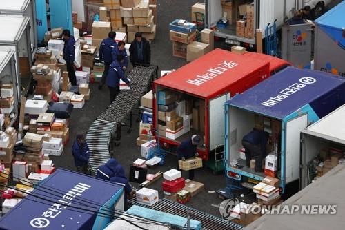 In this file photo, delivery workers sort parcels at a distribution center in Seoul on Jan. 21, 2021. (Yonhap)