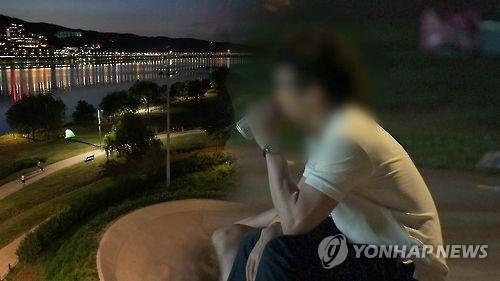 The undated photo provided by Yonhap News TV shows a man drinking a can of beer at a riverside park in Seoul. (PHOTO NOT FOR SALE) (Yonhap)