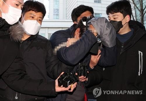 This Dec. 12, 2021, file photo shows a man who allegedly killed his ex-girlfriend's mother and seriously injured her brother at their home in southern Seoul heading to the Seoul Eastern District Court to attend an arrest warrant hearing. (Yonhap)