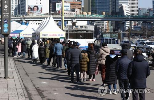 People line up to receive COVID-19 tests in front of a makeshift testing station on Feb. 27, 2022. (Yonhap)