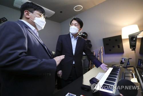 Ahn Cheol-soo (R), chairman of President-elect Yoon Suk-yeol's transition team, converses with Bang Si-hyuk, founder and chairman of Hybe, the management agency of K-pop group BTS, in the company's office in Seoul on April 2, 2022. (Pool photo) (Yonhap)