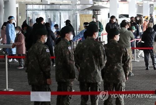 Service members wait in line to receive COVID-19 tests at a gym in Wonju, 132 kilometers southeast of Seoul, on March 22, 2022. (Yonhap)