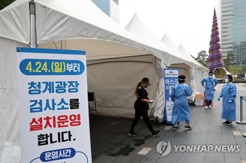 A person waits at a makeshift clinic in central Seoul on April 24, 2022, to get tested for COVID-19. (Yonhap)
