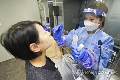A medical worker conducts a COVID-19 test at a testing station in Seoul on May 9, 2022. (Yonhap)