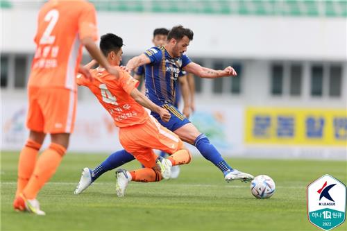 Seo Min-woo of Gangwon FC (C) attempts a tackle on Valeri Qazaishvili of Ulsan Hyundai FC during the clubs' K League 1 match at Gangneung Stadium in Gangneung, 240 kilometers east of Seoul, on May 8, 2022, in this photo provided by the Korea Professional Football League. (PHOTO NOT FOR SALE) (Yonhap)
