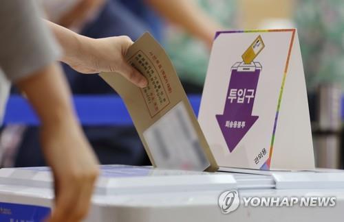 A voter casts ballots at a polling station in Seoul on May 27, 2022, the first day of two-day early voting for the June 1 local elections and parliamentary by-elections. (Yonhap)