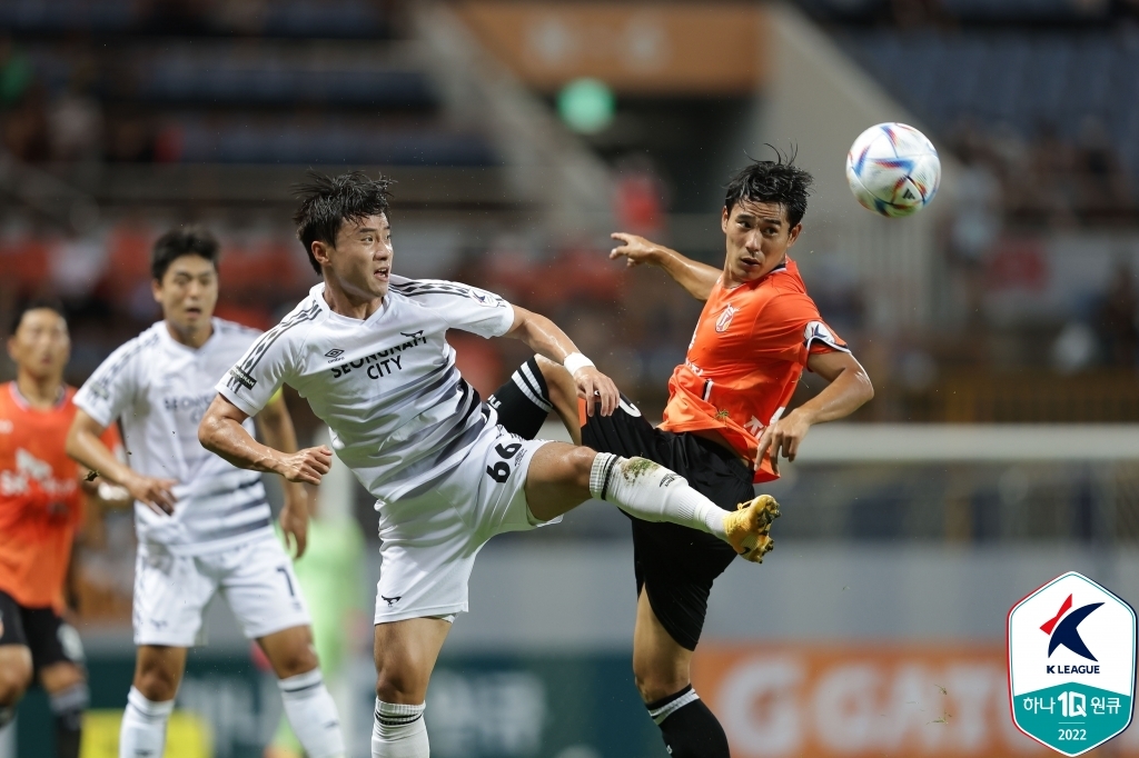 Park Soo-il of Seongnam FC (L) and Jin Seong-uk of Jeju United battle for the ball during their clubs' K League 1 match at Jeju World Cup Stadium in Seogwipo, Jeju Island, on Aug. 2, 2022, in this photo provided by the Korea Professional Football League. (PHOTO NOT FOR SALE) (Yonhap)