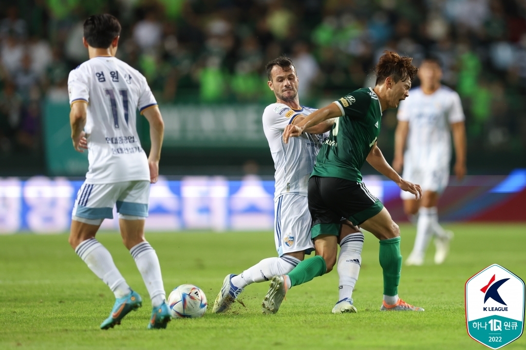 Valeri Qazaishvili of Ulsan Hyundai FC (C) battles Kim Jin-su of Jeonbuk Hyundai Motors for the ball during the clubs' K League 1 match at Jeonju World Cup Stadium in Jeonju, 200 kilometers south of Seoul, on Aug. 7, 2022, in this photo provided by the Korea Professional Football League. (PHOTO NOT FOR SALE) (Yonhap)