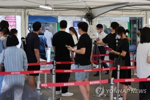 People line up to undergo COVID-19 virus tests at a makeshift testing station in Seoul on Aug. 18, 2022. (Yonhap)