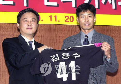 In this file photo from Nov. 20, 2000, LG Twins pitcher Kim Yong-soo (R) holds up his jersey during his retirement ceremony at Jamsil Baseball Stadium in Seoul. (Yonhap)