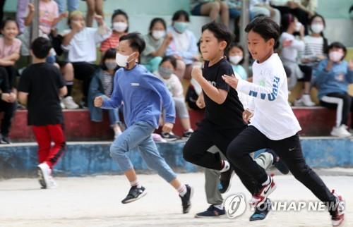 Students without masks run during a field day at an elementary school in Gwangju, 268 kilometers south of Seoul, on Sept. 26, 2022. South Korea lifted all outdoor mask mandates the same day as the country is "clearly overcoming" a resurgence in COVID-19 cases, but the indoor mask mandate will remain in place. (Yonhap)