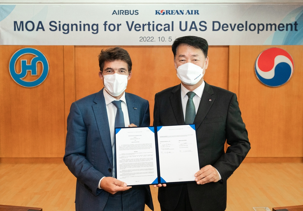 In this photo taken on Oct. 5, 2022, and provided by Korean Air, Park Jung-woo (R), head of the Korean carrier's aerospace business division, and Airbus Helicopters CEO Bruno Even pose for a photo after signing an MOA for unmanned helicopter development at Korean Air's headquarters in Seoul. (PHOTO NOT FOR SALE) (Yonhap)