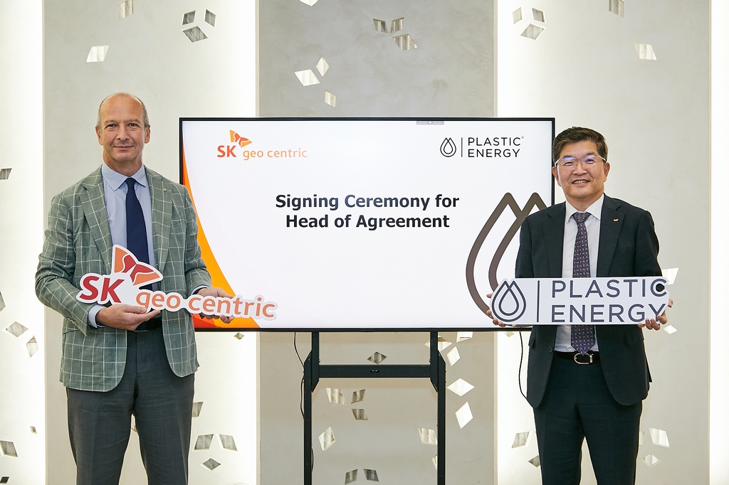 SK Geocentric CEO Na Kyung-soo (R) and Plastic Energy CEO Carlos Monreal pose for photos during a signing ceremony for their partnership for plastic pyrolysis, in this photo provided by SK Geocentric on Nov. 16, 2022. (PHOTO NOT FOR SALE) (Yonhap) 