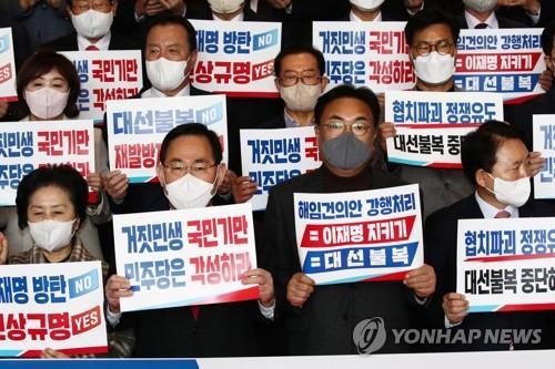 This photo shows members of the ruling People Power Party holding signs at the National Assembly on Dec. 11, 2022, denouncing the main opposition Democratic Party-led passage of a dismissal motion against Interior Minister Lee Sang-min. (Pool photo) (Yonhap)