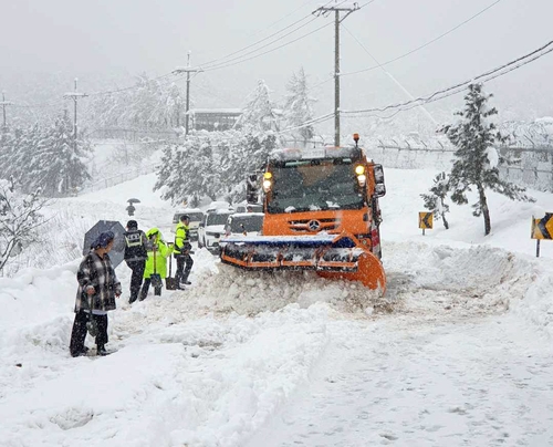 This photo provided by fire authorities shows a snowplow truck moving along a snow-covered road in Gangwon Province on Jan. 15, 2023. (PHOTO NOT FOR SALE) (Yonhap)