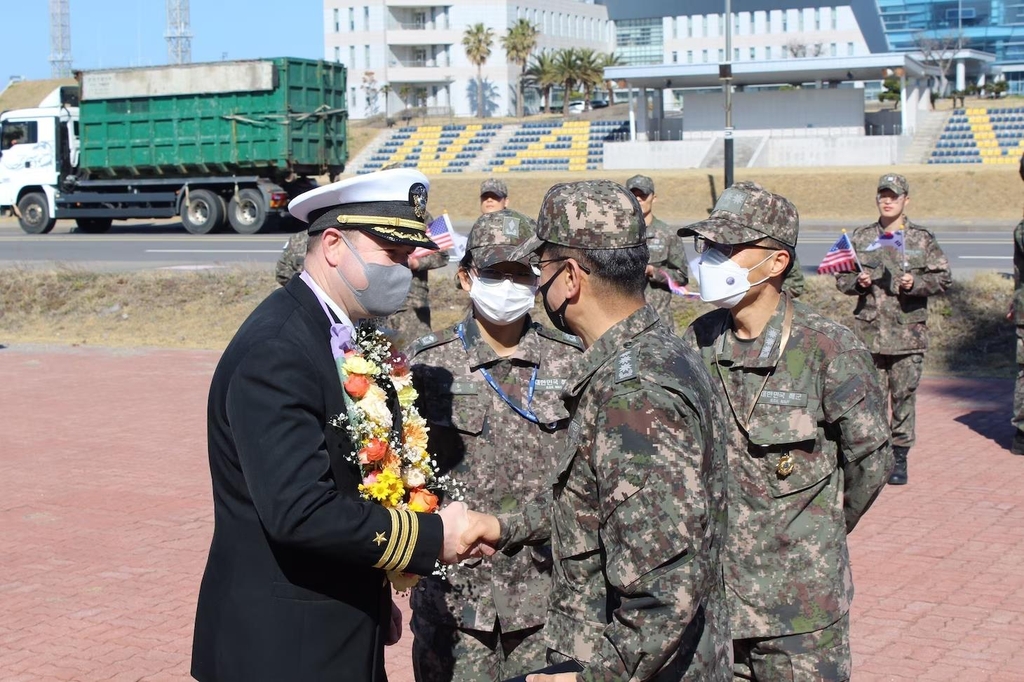 Esta foto del sitio web del Comando del Pacífico de EE. UU. muestra al Cmdr.  Charles Cooper (izquierda), oficial al mando del USS Rafael Peralta, saluda a oficiales militares coreanos durante una visita programada al puerto de la isla sureña de Jeju el 27 de febrero de 2023. (FOTO NO A LA VENTA) (Yonhap)