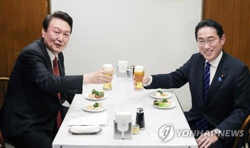 President Yoon Suk Yeol (L) and Japanese Prime Minister Fumio Kishida toast at a restaurant after their summit in Tokyo on March 16, 2023. (Yonhap)