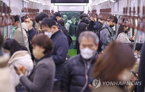 Most passengers remain masked up on a subway train in Seoul on March 20, 2023, the first day the mask mandate is lifted for public transportation. (Yonhap)