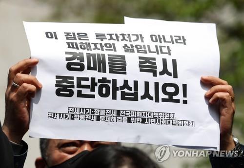 Un hombre sostiene un mensaje de protesta frente al Tribunal de Distrito de Incheon en Incheon, 27 kilómetros al oeste de Seúl, el 21 de abril de 2023, pidiendo remedios para las víctimas de estafas de alquiler de viviendas.  (Yonhap)