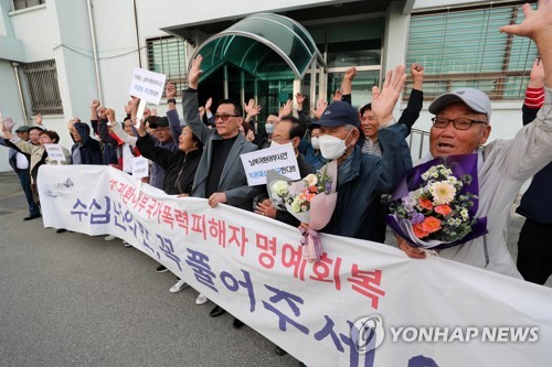 A group of fishermen once abducted by North Korea cheer after they were cleared of violations of anti-communist and security laws in a retrial by a district court in the city of Chuncheon, 75 kilometers northeast of Seoul, on May 12, 2023. (Yonhap) 
