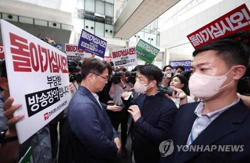 A police investigator shows his ID before protesting labor union members of MBC at the broadcasting network's headquarters in western Seoul on May 30, 2023. (Yonhap)